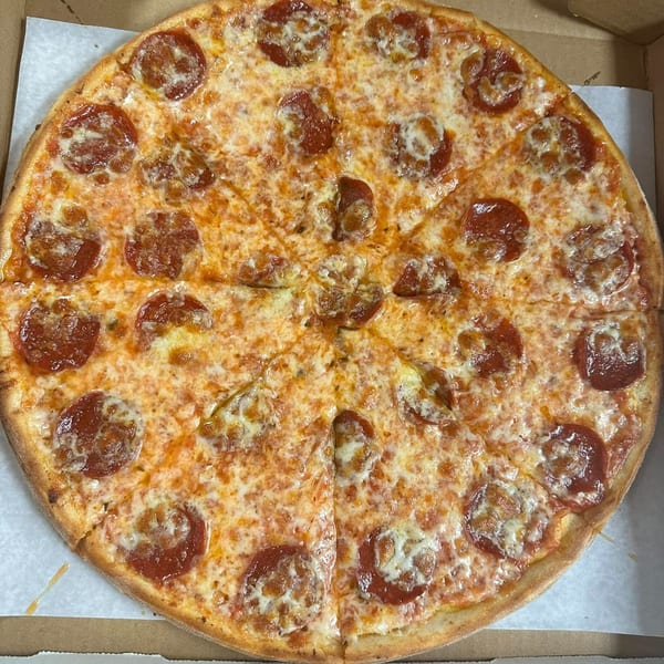 A whole pepperoni pizza from Familia Pizza, sliced and ready to eat in a cardboard box.